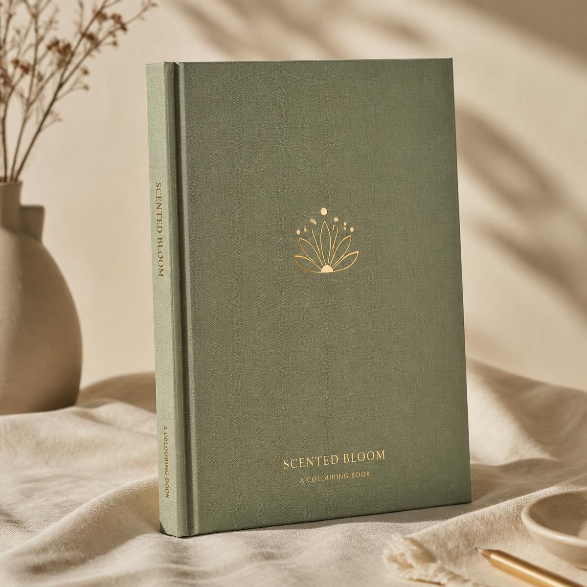 Arriving, a sage cloth-bound colouring book with an antique gold foil bloom
